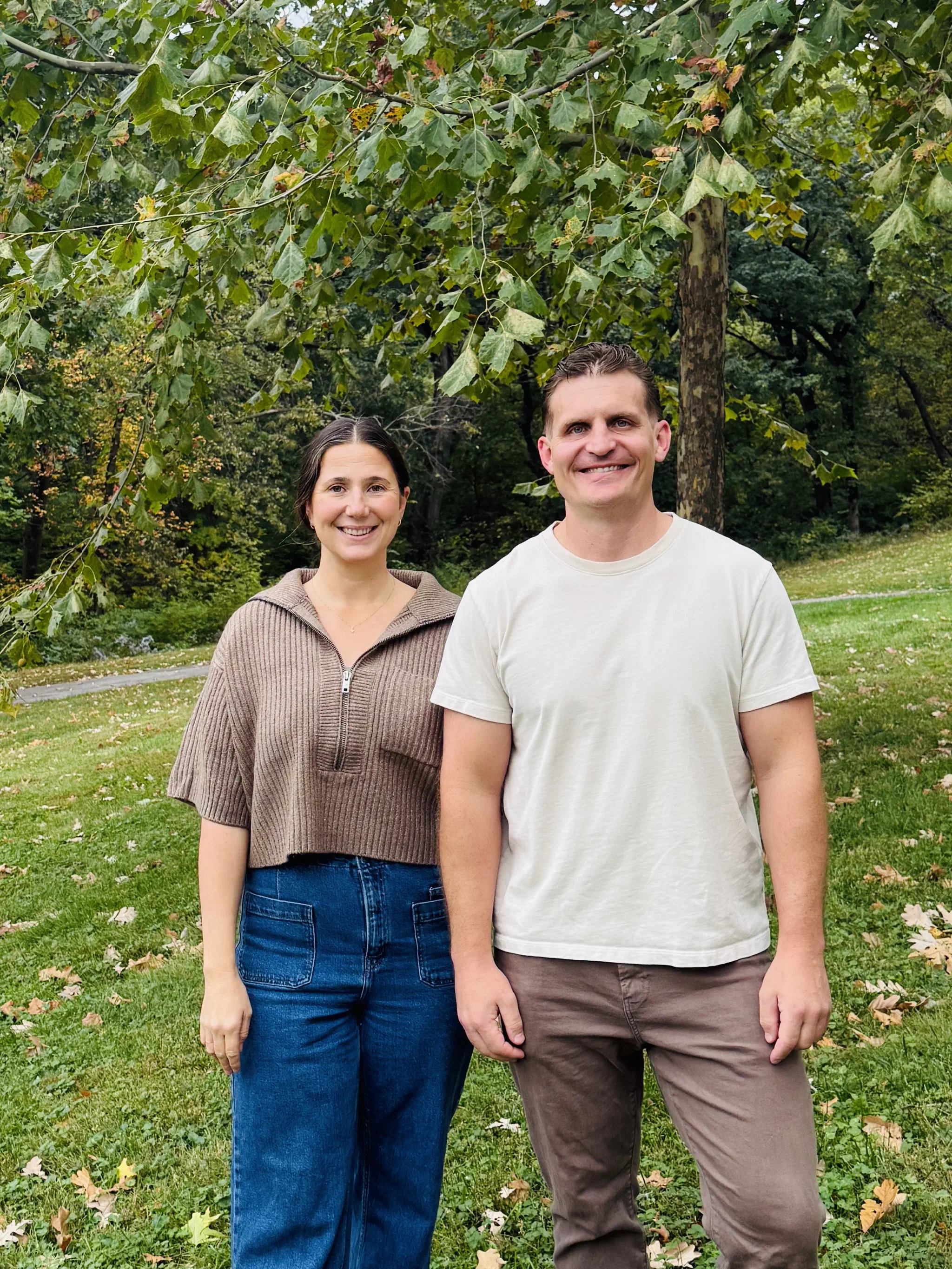 Stetson and Angela from Tis The Season Holiday Lighting standing together outdoors under a tree